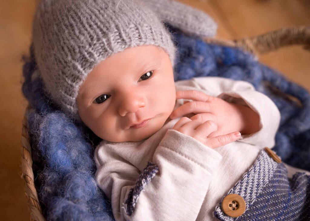 Lächelndes Neugeborenes mit Mütze beim Newborn Shooting in Mainz
