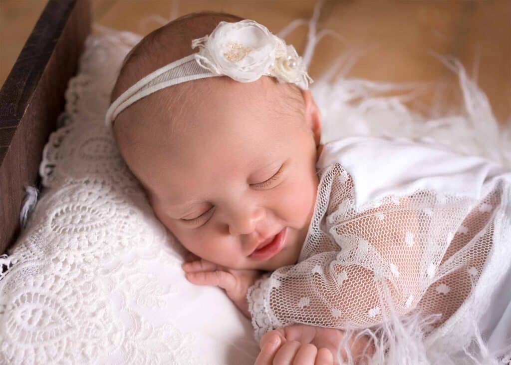 Schlafendes Neugeborenes in weißem Outfit bei einem natürlichen Newborn Shooting in Wiesbaden