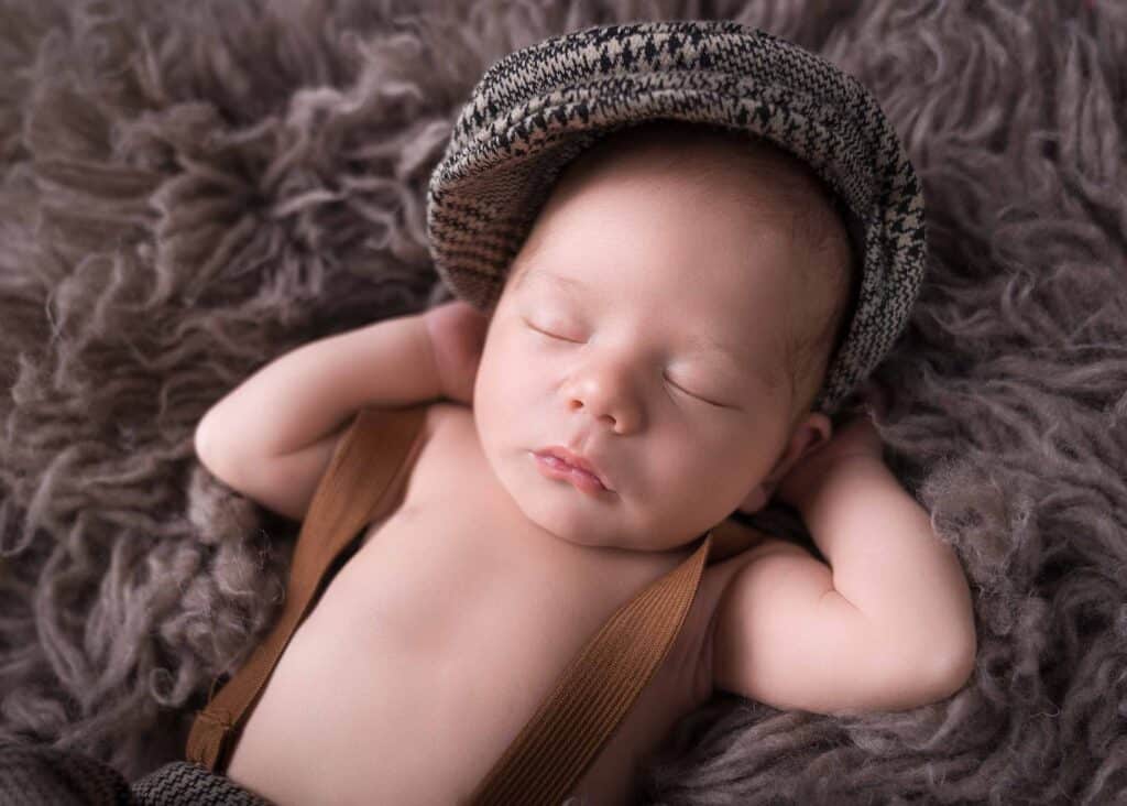 Schlafendes Baby mit Mütze und Hosenträgern beim Newborn Shooting in Wiesbaden